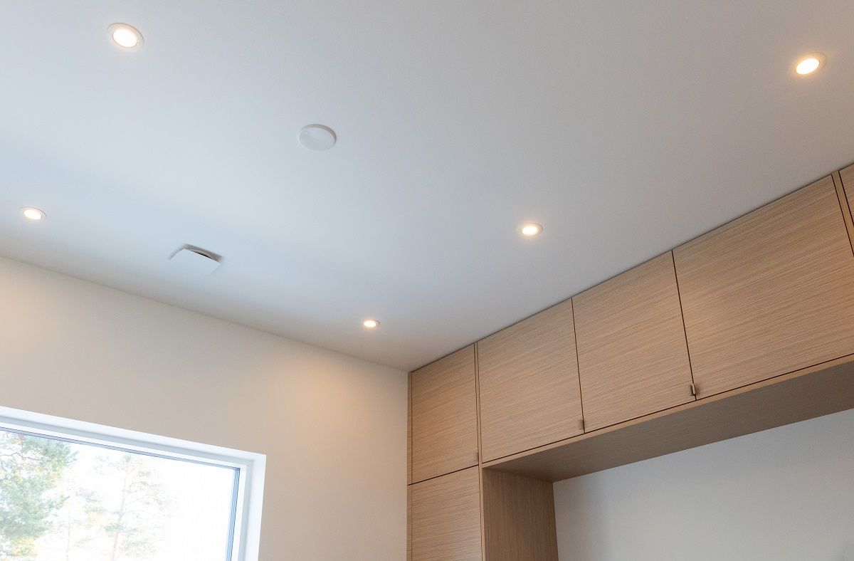 The ceiling lights in the guest room are symmetrically positioned in the space, emphasising the edges of the room and providing the necessary lighting in front of the cabinets.
